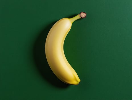 Single ripe yellow banana on green background photo