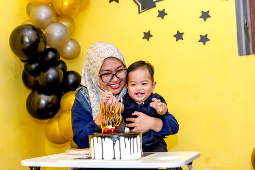 Mom and her son smiling happily when celebrating his birthday. Adorable moments of young family photo