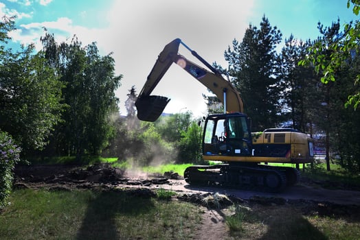 Excavator during earthmoving at open pit on blue sky background On a wonderful day with a positive attitude photo