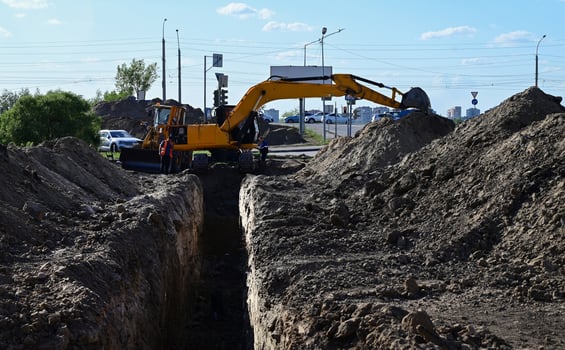 Excavator on a wonderful day during earthmoving at open pit on blue sky background on a wonderful day. Construction machinery and earth-moving heavy equipment for excavation, loading photo