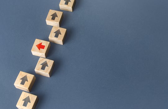 Red arrow stands out from the others and changes direction to go out of order. Thinking outside the box. New strategies and solutions. Atypical, leadership qualities. Denial of conformism. photo