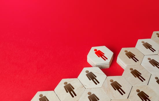 A man leaves a formation of people figurines hexagons. Violation of the integrity of the system, non-conformist. Integration of a person into society. Staff recruitment, recruiting. Exception from photo