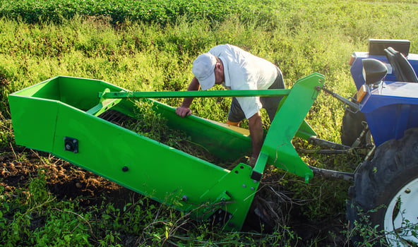 The farmer inspects and repair adjustment of agricultural equipment for digging out potatoes. Harvesting potatoes in autumn. Exploitation and maintenance of equipment. Farming agriculture and farmland photo