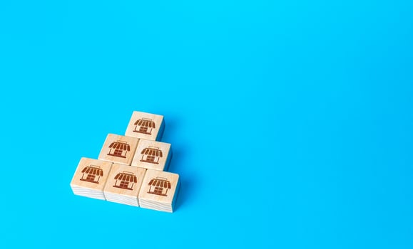 Block pyramid with shop symbols. Franchising concept. Business franchise. Commercial association. Business management. Retail and trade. Organization and structuring. Investment in commerce. photo