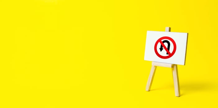 Easel with no turning back traffic sign on a yellow background. Assertiveness and striving, moving forward without retreating. Go to the goal, don't stop. Finish things. There is no way back. photo