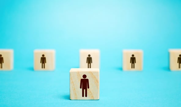 A block man stands out from a row number of people. Leader, leadership skills. Filling of vacancies with professional specialists. Staffing. Talented employee. Concept of individuality and personality photo