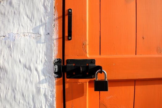 A Vibrant and Striking Orange Door, Complete with Lock and Multiple Security Features photo