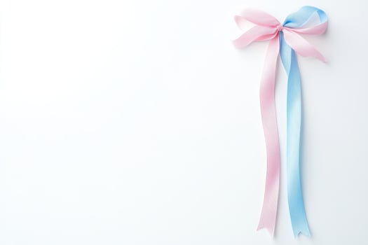 Elegant pink and blue ribbon bow on white background symbolizing celebration photo