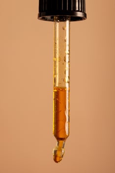 yellow oil pouring out of a pipette photo