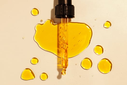 yellow oil pouring out of a pipette aerial view photo