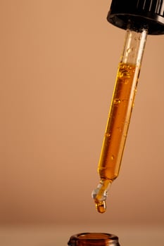 drops of oil pouring out of a pipette to the bottle photo
