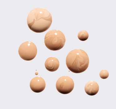 drops of different shades of foundation on a white background photo
