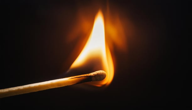 Burning match stick on dark black background. photo