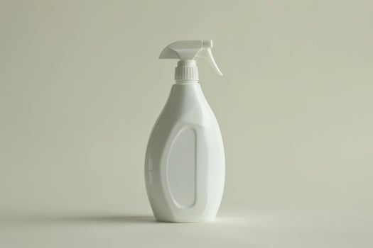 White plastic spray bottle standing on light background photo