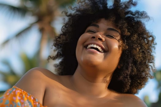 Carefree black woman enjoying tropical vacation with big laugh photo