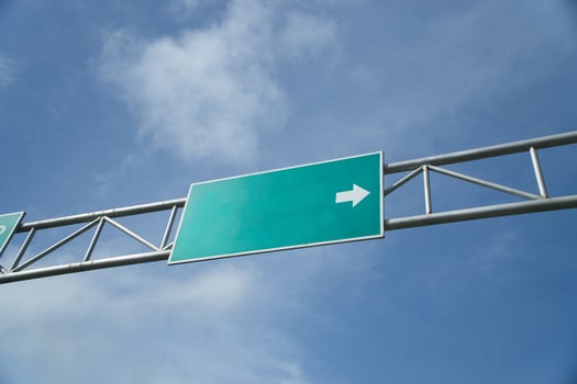 Blank Road Sign with an Arrow Beneath a Clear Blue Sky photo