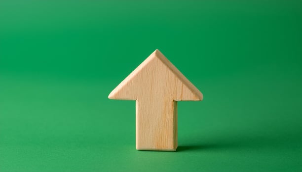 Minimalist wooden arrow on green background. Wood pointer, forward direction, up. photo