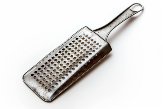 Old metal grater resting on white background photo