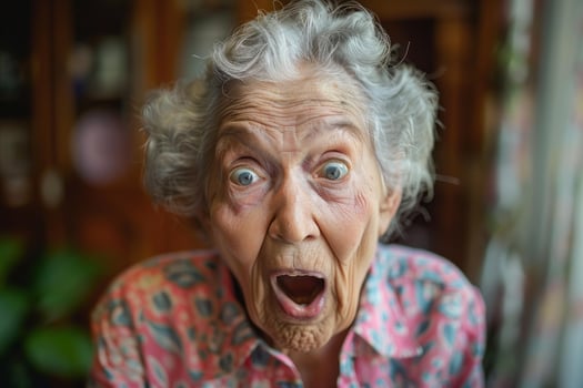Surprised senior woman opening her mouth and eyes wide photo