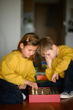 Around the chessboard, children in yellow sweaters discuss their next move. photo