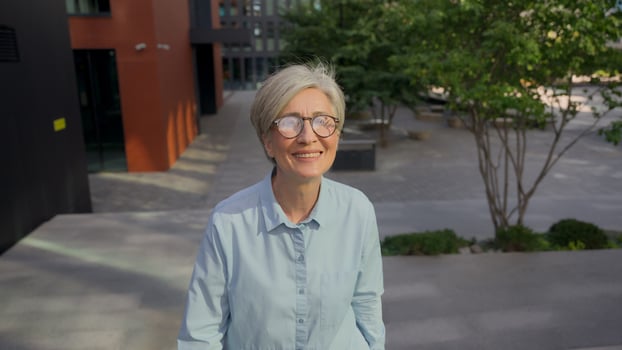 Smiling adult Caucasian businesswoman mature senior middle-aged gray-haired business woman happy 50s female walking up stairs in city outdoors confident going upward walk steps dreaming career success photo