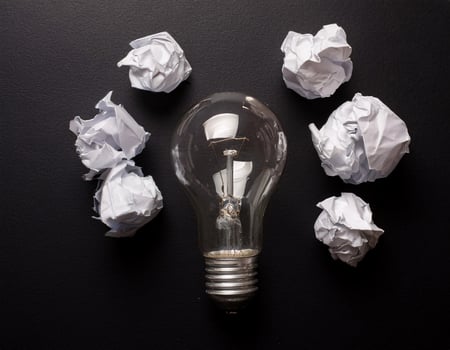 Lightbulb and Crumpled Paper Symbolizing Inspiration, Shot from Above photo