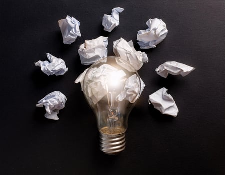 Creative Idea Concept with Lamp and Crushed Paper on Black Background photo