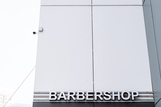 A sign on a building that says barbershop photo