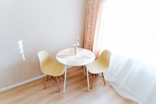The room contains a table and two chairs made of wood photo
