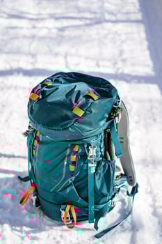 A blue backpack sitting on the snow photo