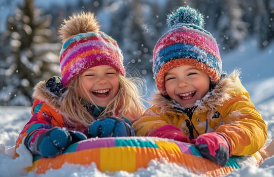 Two little girls in winter clothes are having fun on a sled photo