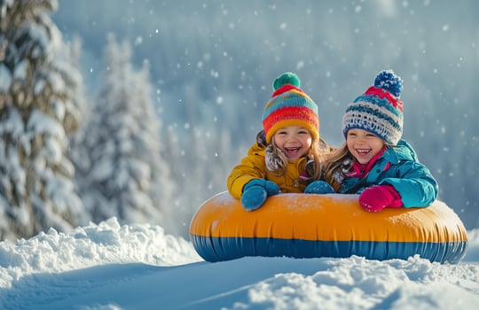 Two children in winter clothes on an inflatable tube photo