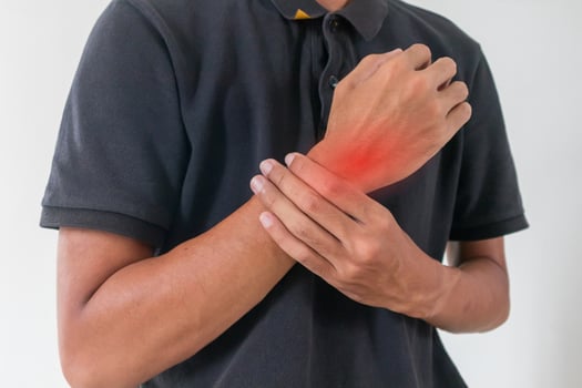 A man holding his sore or painful wrist photo
