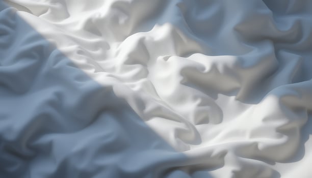 White fabric with soft folds and a strong beam of light creating shadows photo