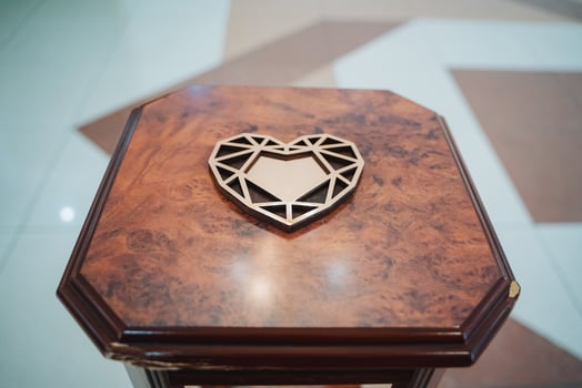 A wood heart rests on a wood table, showcasing symmetry and natural beauty photo