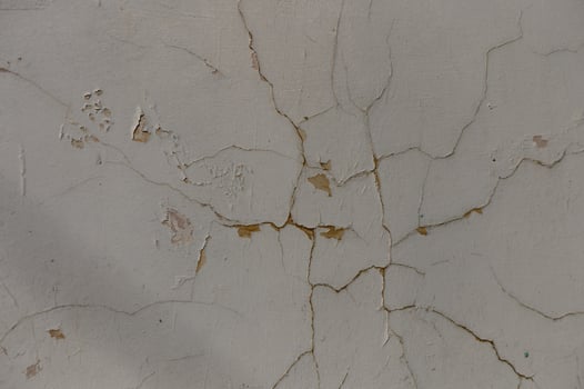 Cracked plaster revealing the beauty of age in an abandoned urban setting with faded charm photo
