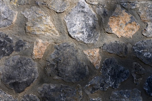 Beautifully textured stone wall showcasing natural colors and unique shapes in soft sunlight photo