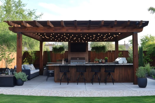 Outdoor kitchen featuring pergola, grill, and string lights illuminating backyard patio photo