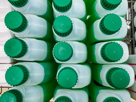 A fascinating collection of a variety of green and white bottles has been meticulously stacked one on top of another, creating a towering display of these colorful cylindrical containers photo