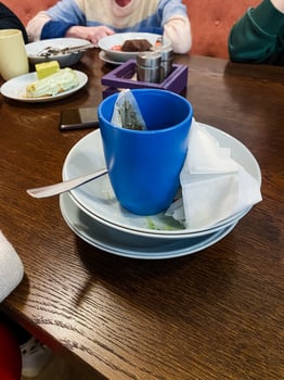 A vibrant blue cup is elegantly placed atop a neatly arranged stack of plates, creating a beautiful display of tableware perfect for any dining setting or special occasion photo