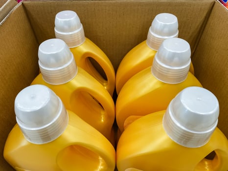A rectangular box packed with vibrant yellow bottles, each topped with white caps, indicating the various contents within, likely filled with delicious liquids such as syrup or juice photo