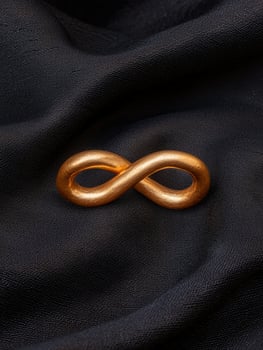 Gold infinity symbol on black fabric photo