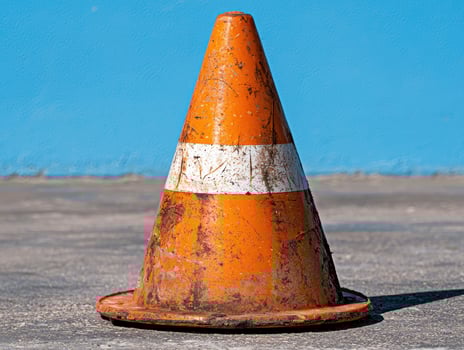 Old orange traffic cone on the ground photo