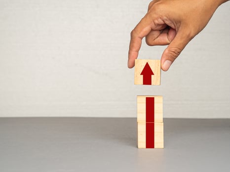 Business growth concept. Wooden cubes with red arrows up a point on a gray background photo