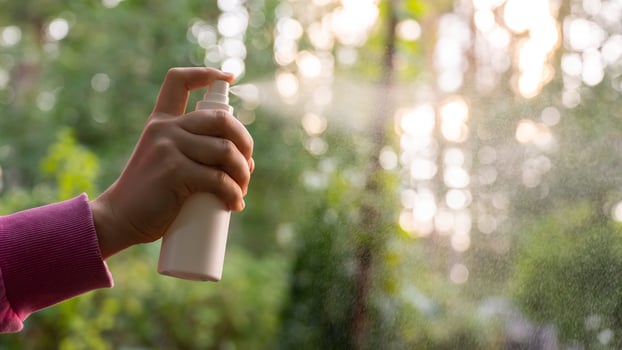 Unrecognizable woman using insect sprays disease prevention. Protection against mosquito bite during summertime. Safety skin treatment outdoors photo
