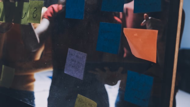 People looking at a board with sticky notes on it photo