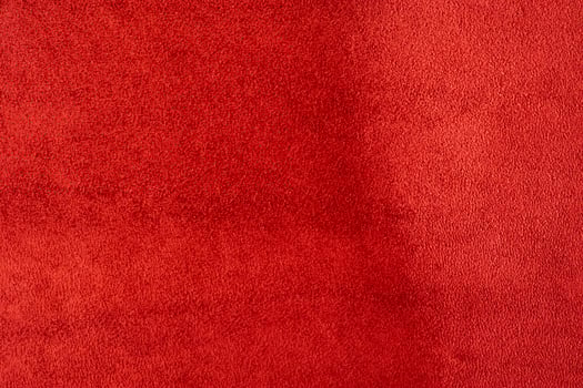 Natural red suede leather as a macro photo background.