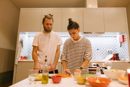 A Couple Enjoying Cooking Together in Their Beautiful, Modern Kitchen Space with Joyful Energy photo