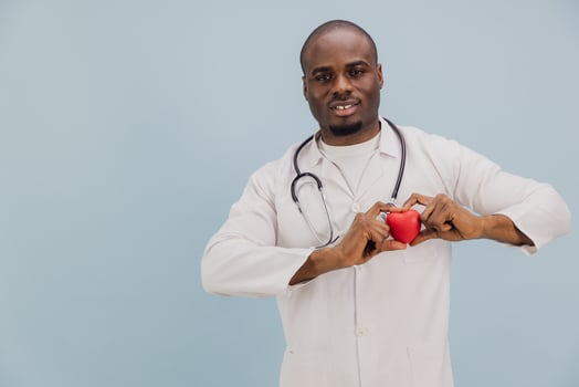 African American Doctor Showing Red Heart on Blue Background photo
