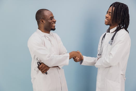 Two Smiling African American Doctors Shaking Hands on Blue Background photo